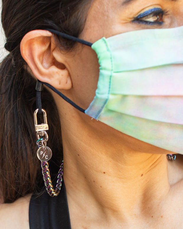 Face mask worn with braided iridescent rainbow chain on woman