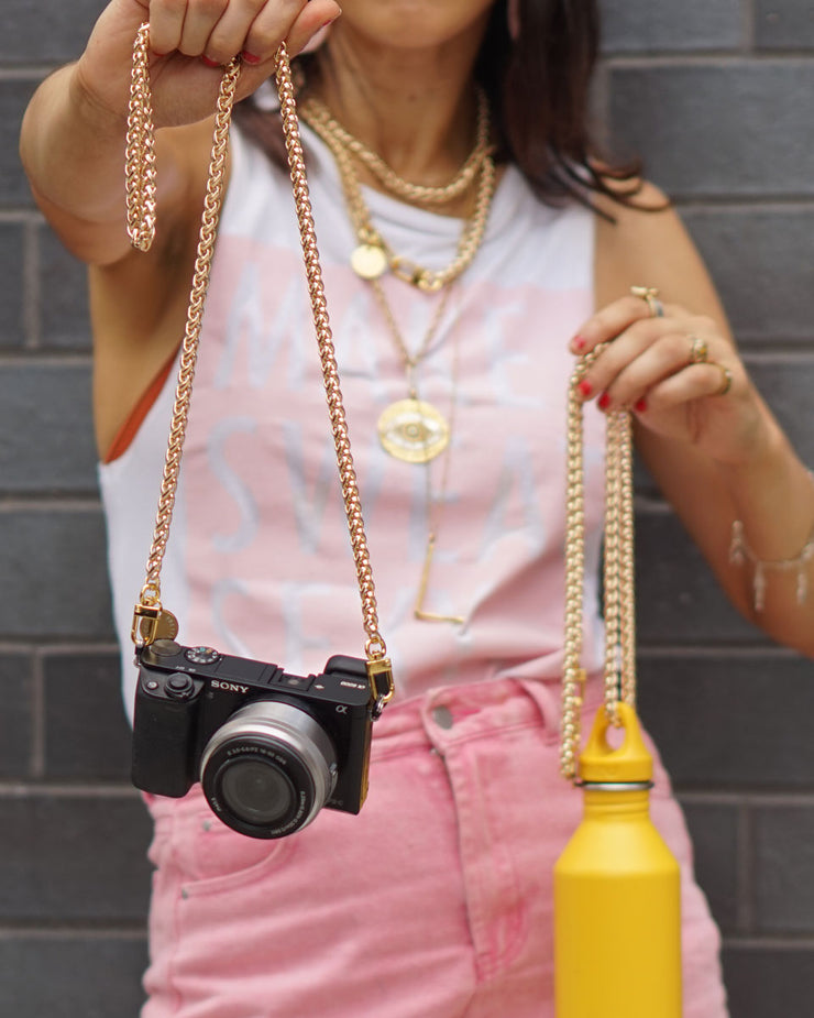 Gold long braided Nikki chain shown as a camera strap and water bottle holder