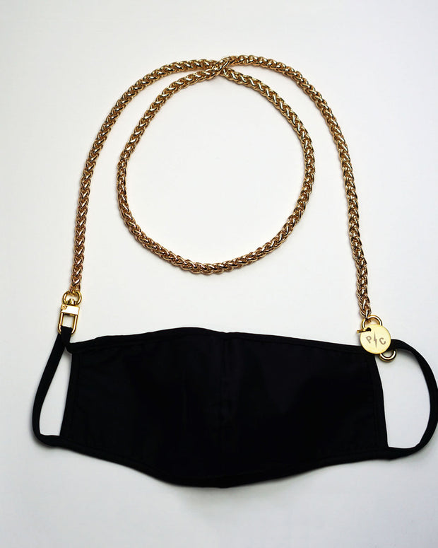 Product shot on white with our long gold face mask chain holder attached to a black mask
